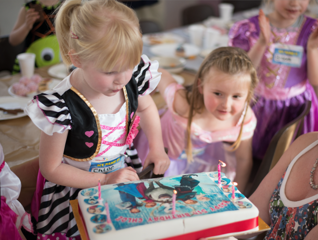 Birthday girl blowing out cake